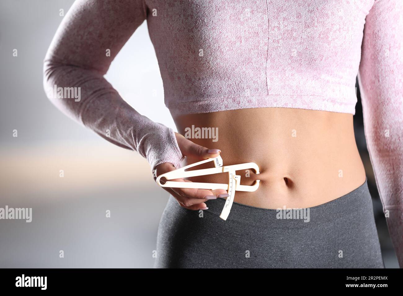 Body fat calipers, woman measuring subcutaneous percentage of fat