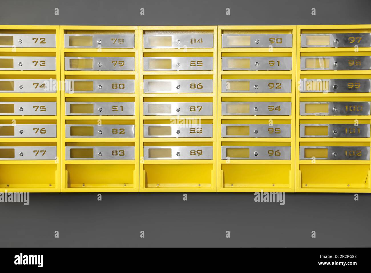 Many closed metal mailboxes with keyholes and numbers in post office