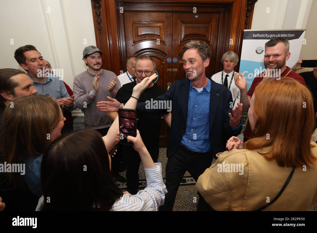 Michael Collins (centre right) from People Before Profit, who has won the last seat, at Belfast City Hall during the Northern Ireland council elections. Picture date: Saturday May 20, 2023. Stock Photo
