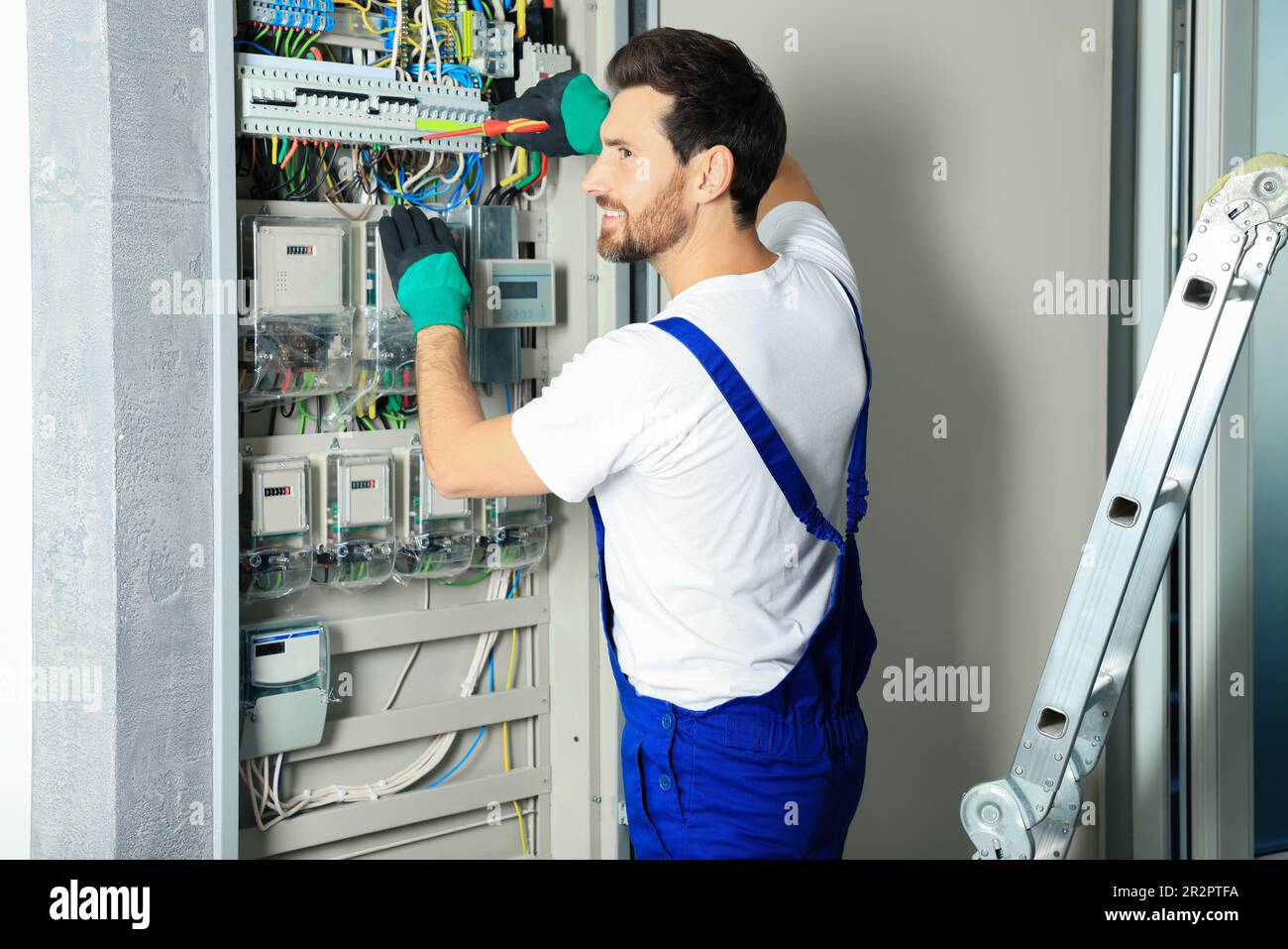 Electrician repairing fuse box with screwdriver indoors Stock Photo - Alamy