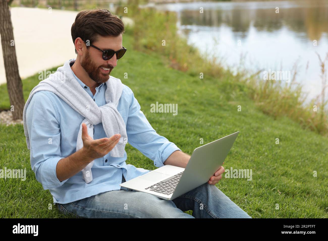 Handsome man sitting near lake hi-res stock photography and images - Alamy