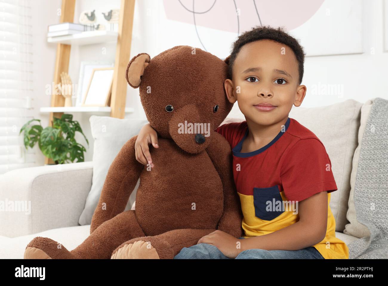 Cute African-American boy with big teddy bear at home Stock Photo - Alamy