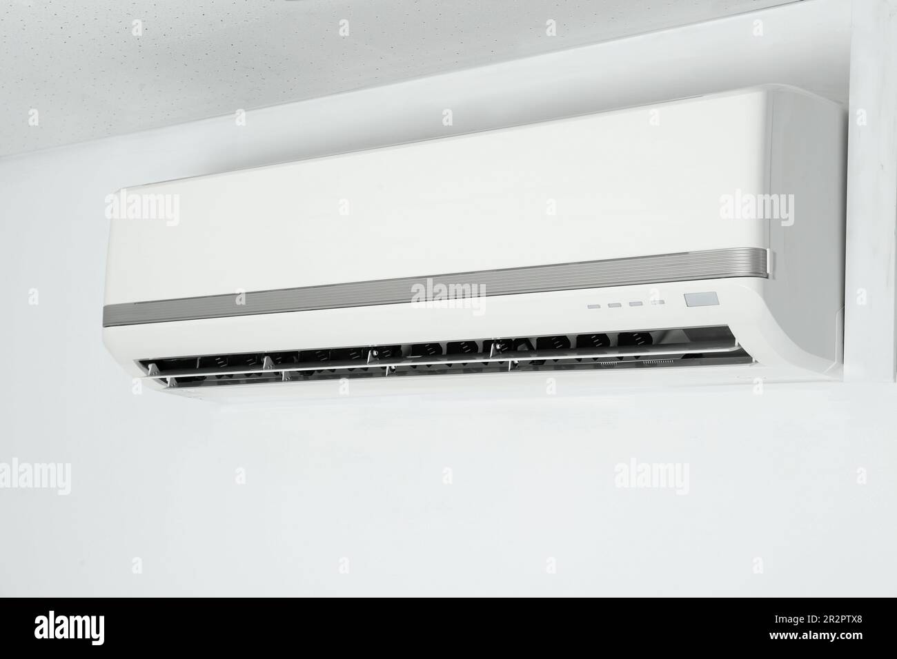 Modern air conditioner on white wall indoors Stock Photo - Alamy
