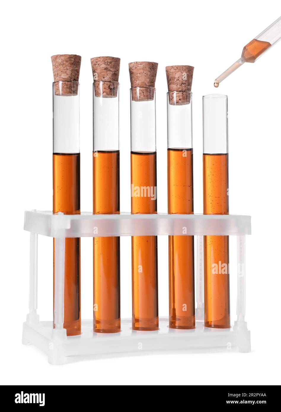 Dripping brown liquid from pipette into test tube on white background