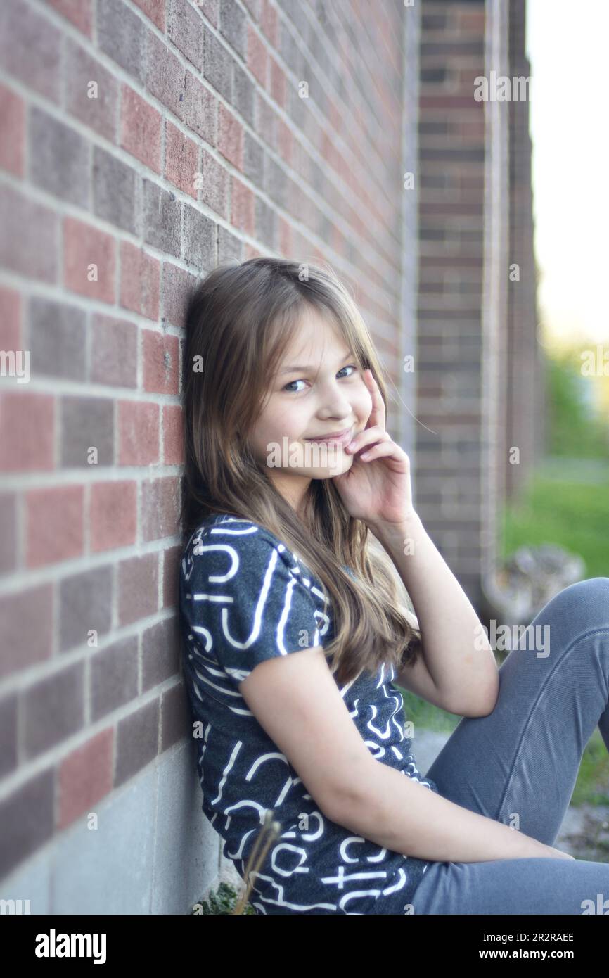 Pretty young blond hair girl posing with smile and confidence outdoors Stock Photo