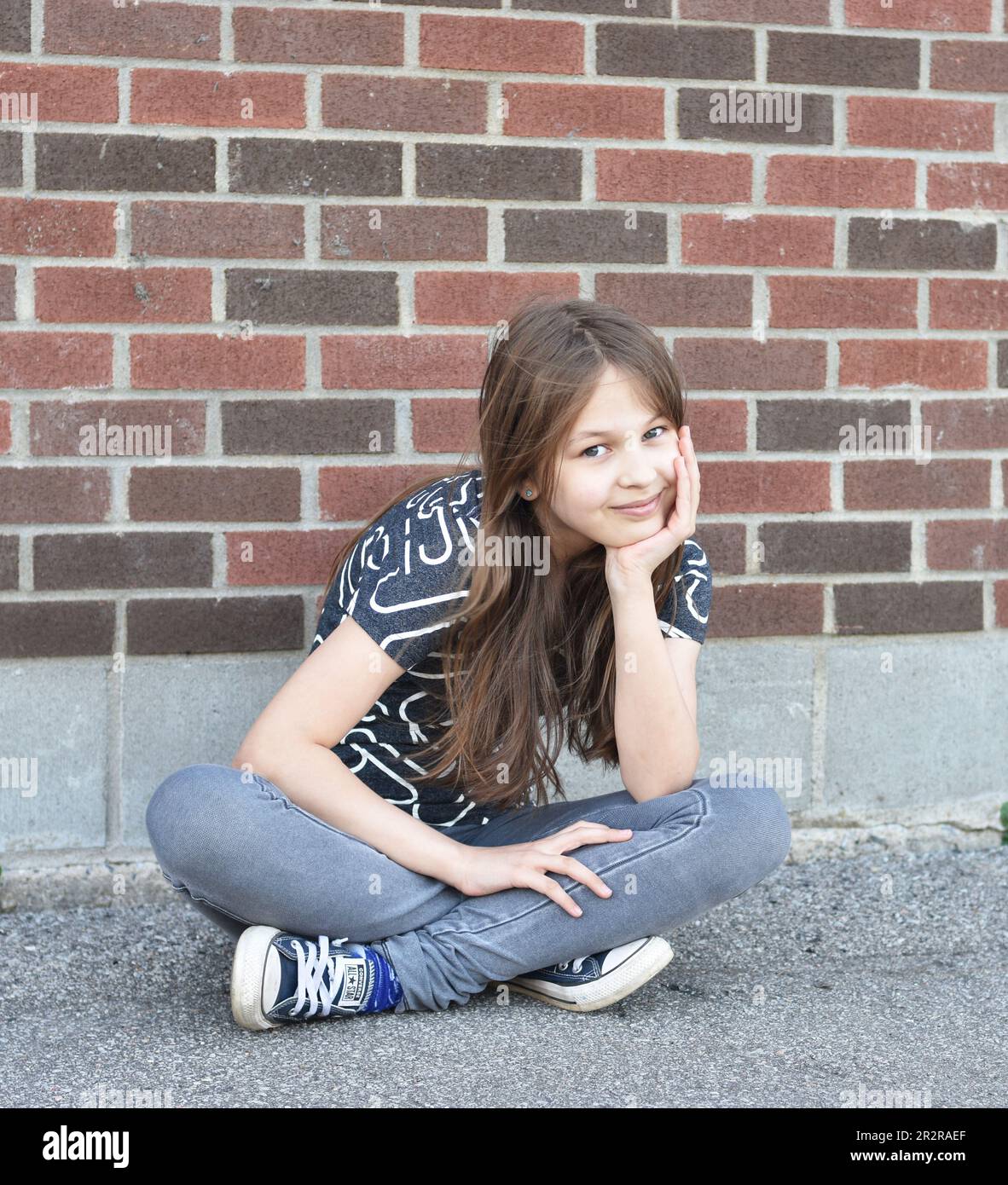 Pretty young blond hair girl posing with smile and confidence outdoors Stock Photo