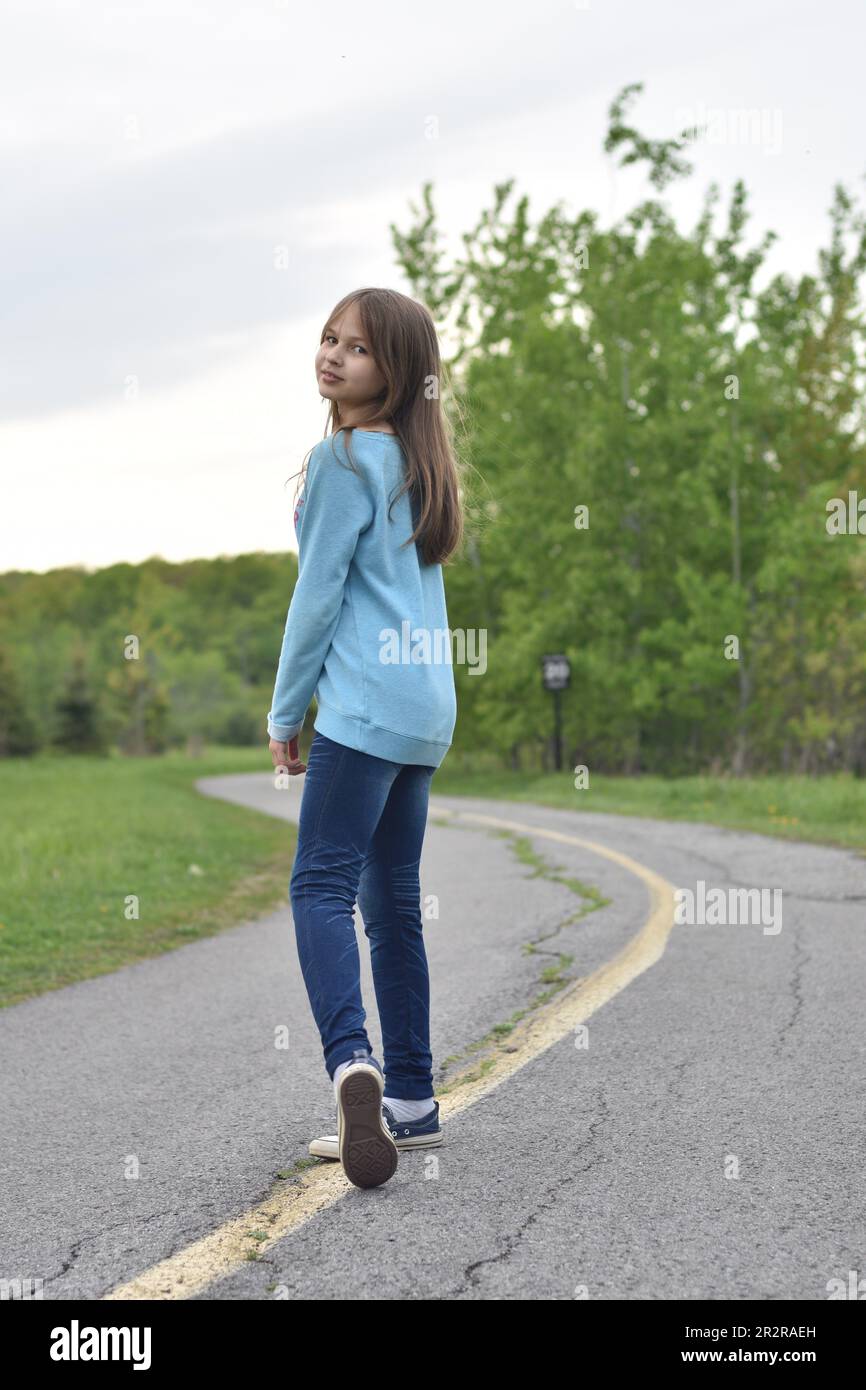 Pretty young blond hair girl posing with smile and confidence outdoors Stock Photo