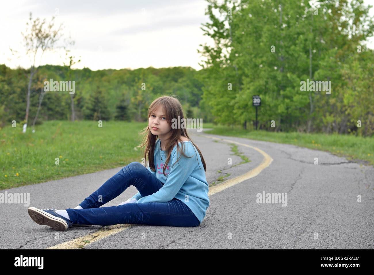 Pretty young blond hair girl posing with smile and confidence outdoors Stock Photo