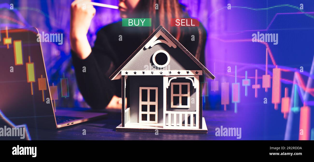 concept of buying and selling real estate. A man with a model of a house on the background of the forex Stock Photo