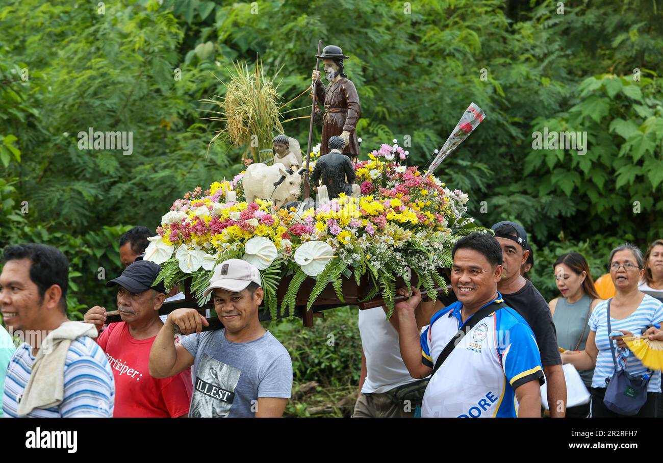 Religious procession in the Philippines bearers support a statue of a saint & wreaths of