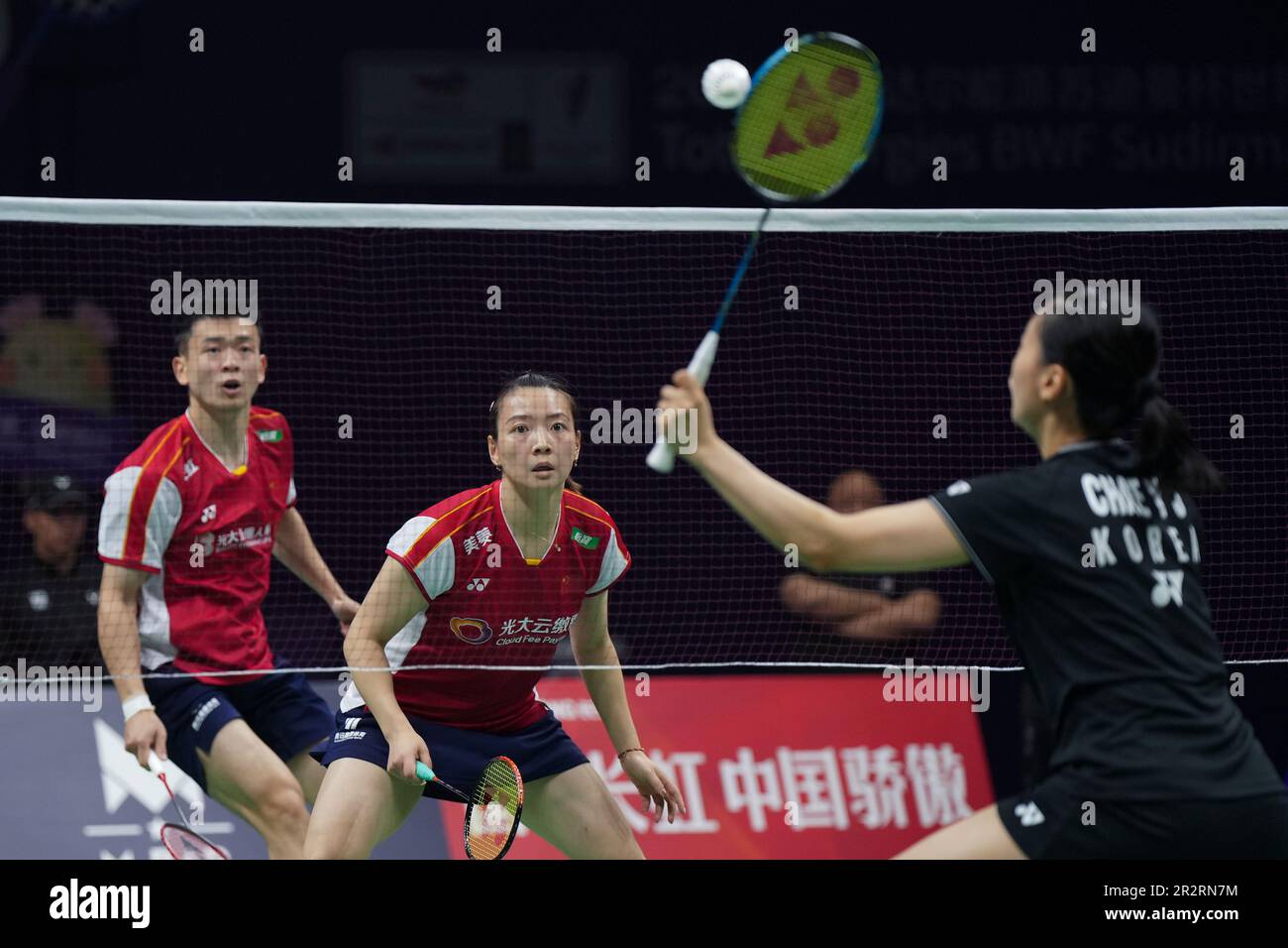 Huang Yaqiong, center, and teammate Zheng Siwei of China watch Chae Yu Jung of South Korea hits a shot during their mixed doubles badminton final match at the BWF Sudirman Cup in
