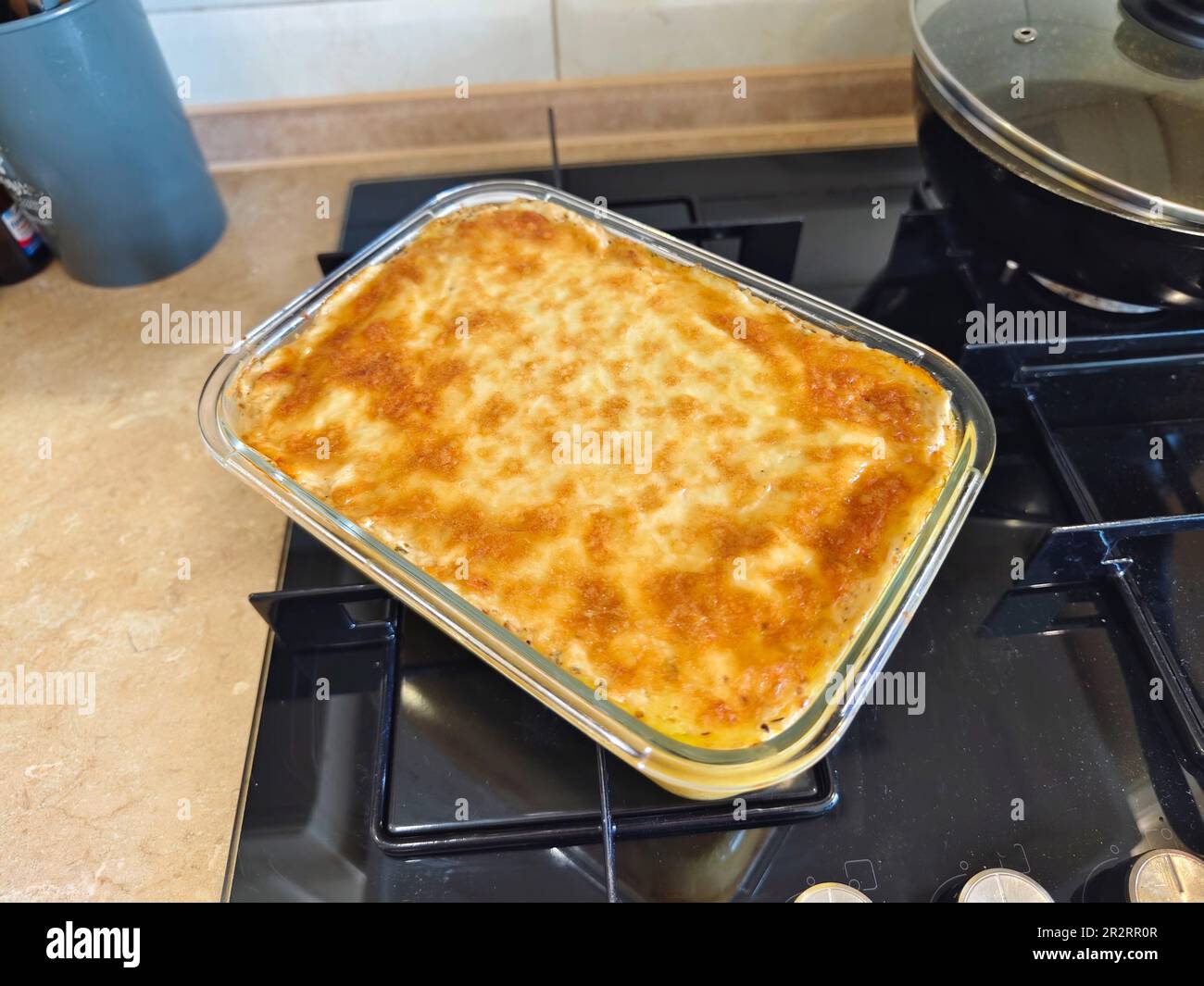 Hearty potato gratin with parmesan cheese cream and delicious cured bacon  freshly served from the oven on a wooden table Stock Photo