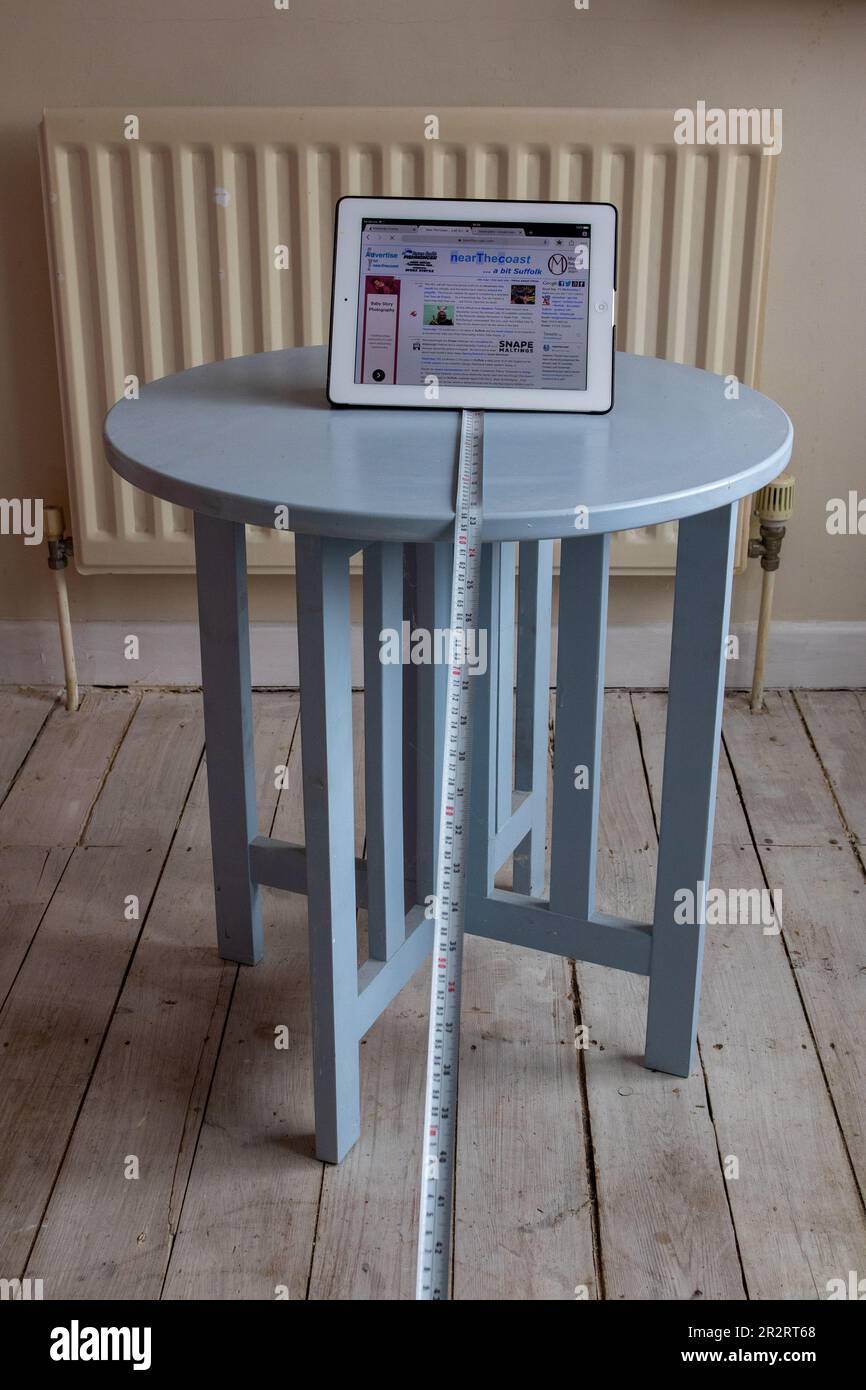 iPad on a pale blue occasional table with an expanding steel rule