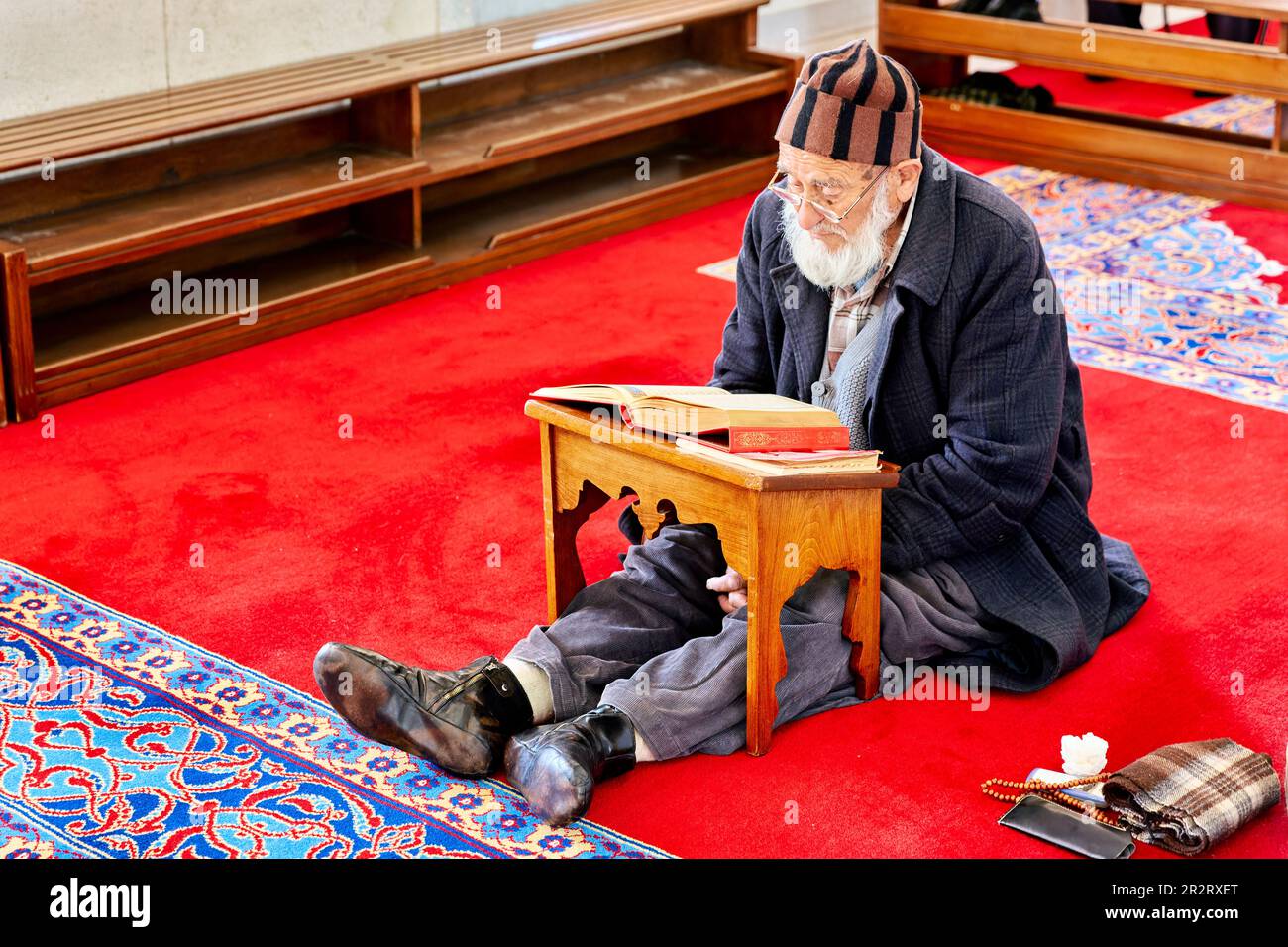 Istanbul Turkey. Muslim believer praying and reading Koran in the Fatih Mosque Stock Photo