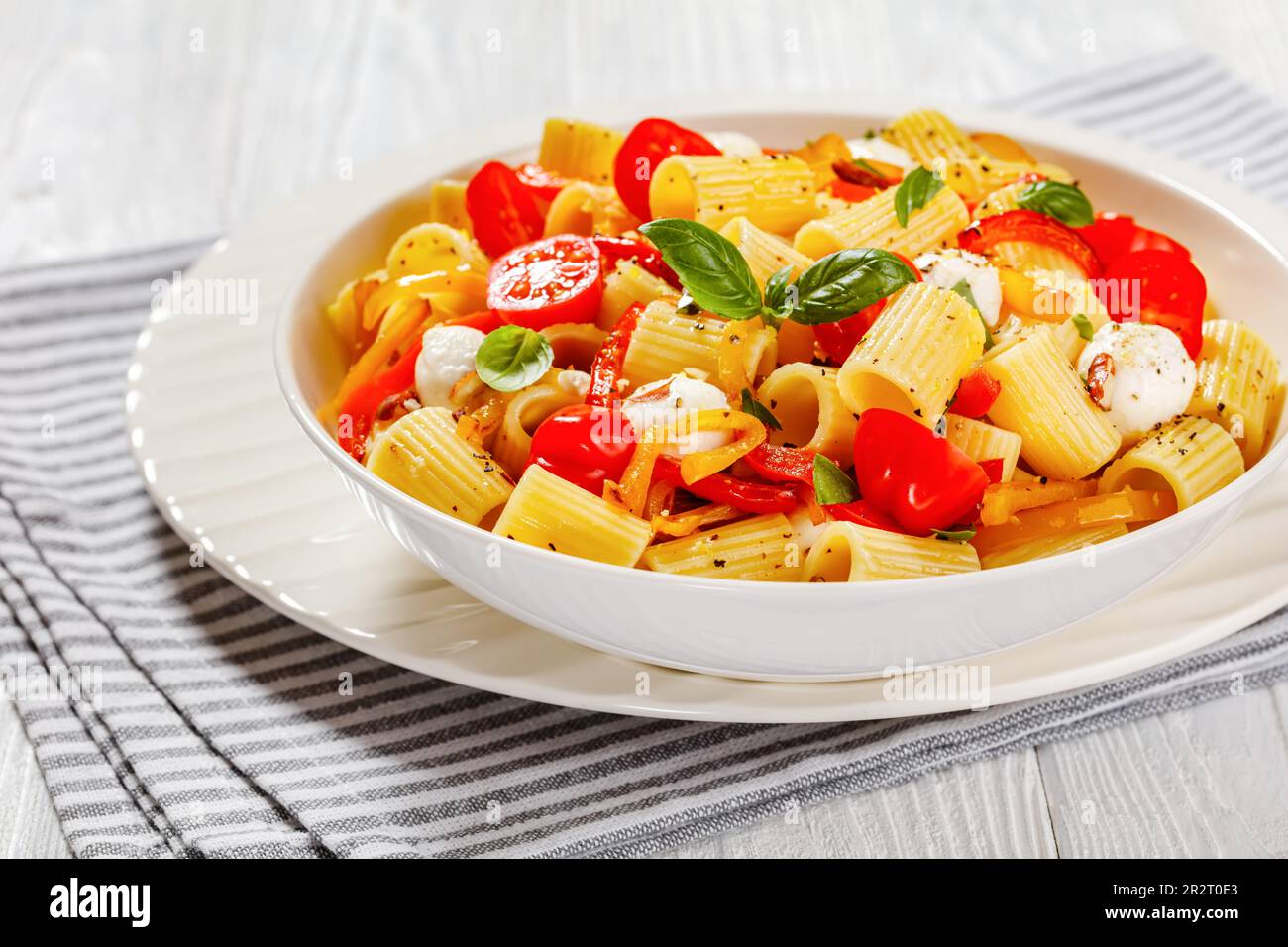 roasted pepper tomato mozzarella pasta salad in white bowl on white ...