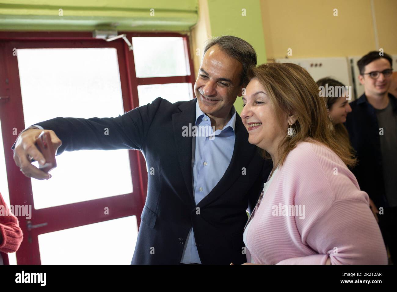 Athen, Greece. 21st May, 2023. Kyriakos Mitsotakis, Greek prime minister and leader of the conservative Nea Dimokratia (ND) party, takes a selfie with a voter after casting his ballot at a polling station in the Kifisia district. These are the first Greek parliamentary elections since the country's economy ceased to be subject to strict monitoring and control by the international lenders who provided bailout money during the nearly decade-long financial crisis. Credit: Socrates Baltagiannis/dpa/Alamy Live News Stock Photo