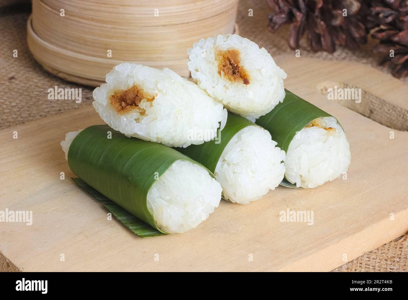 Indonesian traditional food lemper. rice cakes with banana leaves and chicken inside Stock Photo