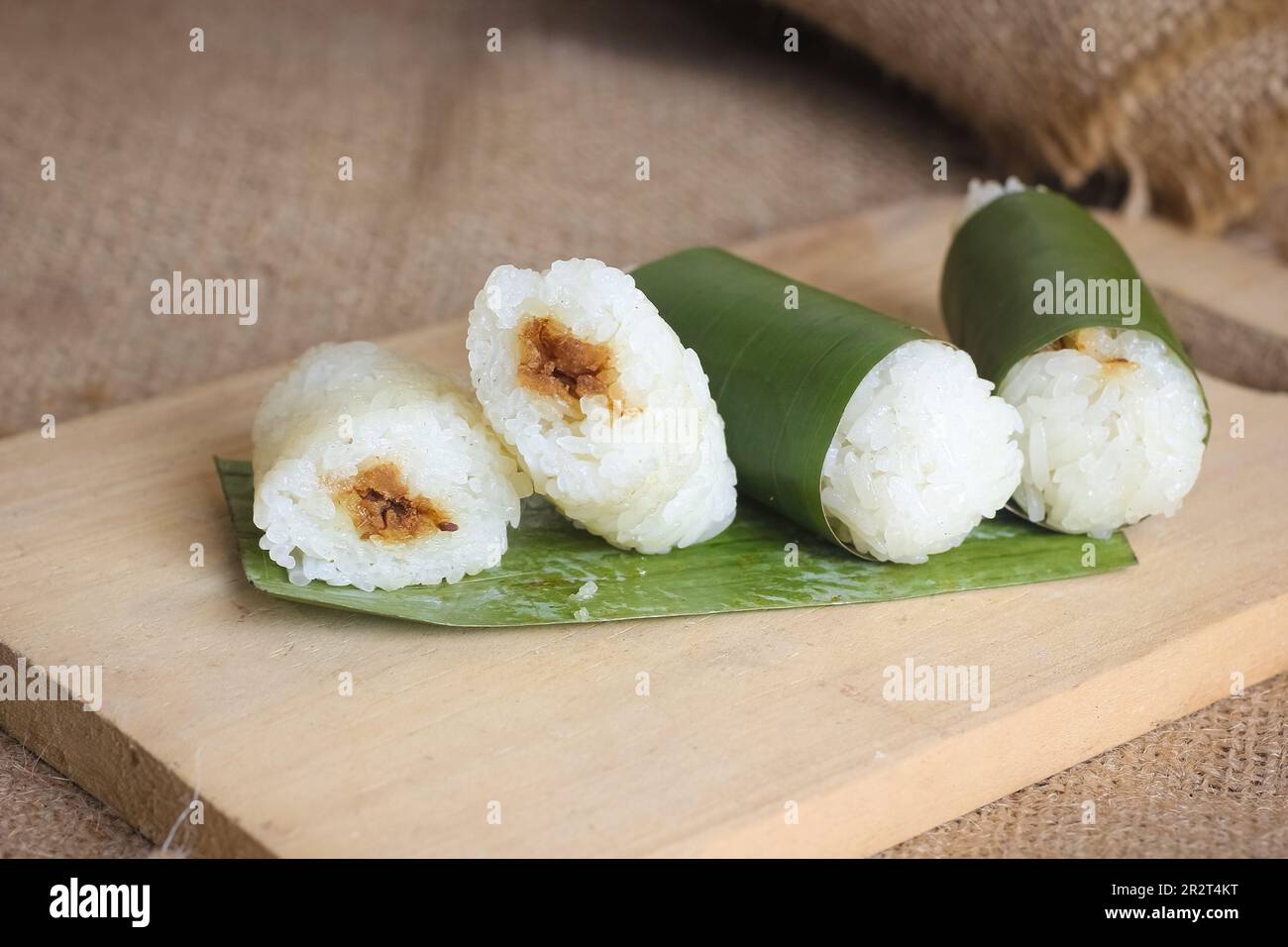 Indonesian traditional food lemper. rice cakes with banana leaves and chicken inside Stock Photo