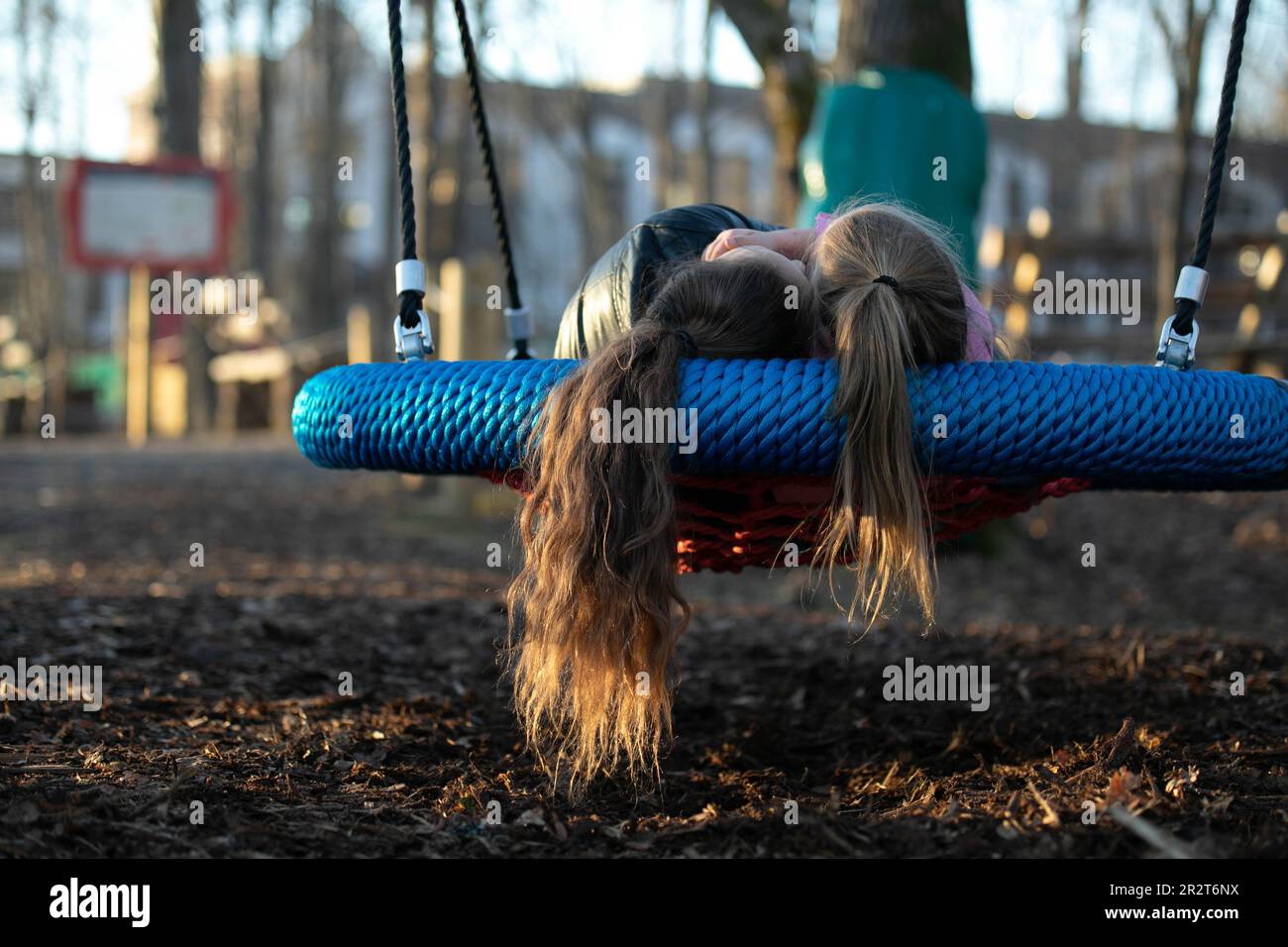 2 girls swinging on a swing Stock Photo - Alamy