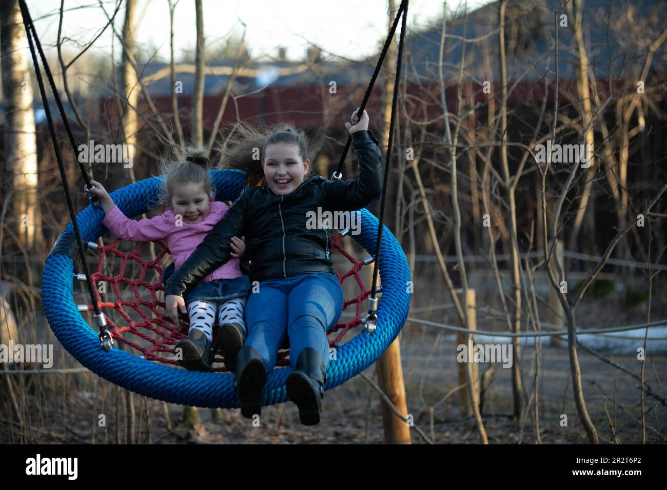 2 girls swinging on a swing Stock Photo - Alamy