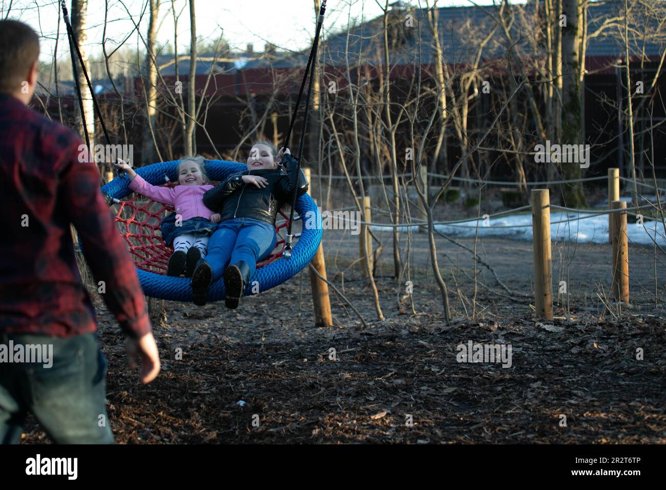 2 girls swinging on a swing Stock Photo - Alamy