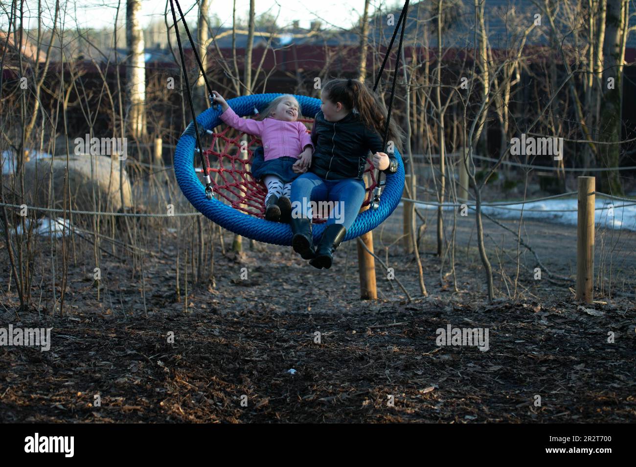2 girls swinging on a swing Stock Photo - Alamy