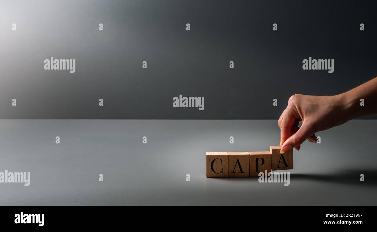 hand posing wooden blocks ,CAPA , acronym for corrective and preventive action ,background for business Stock Photo