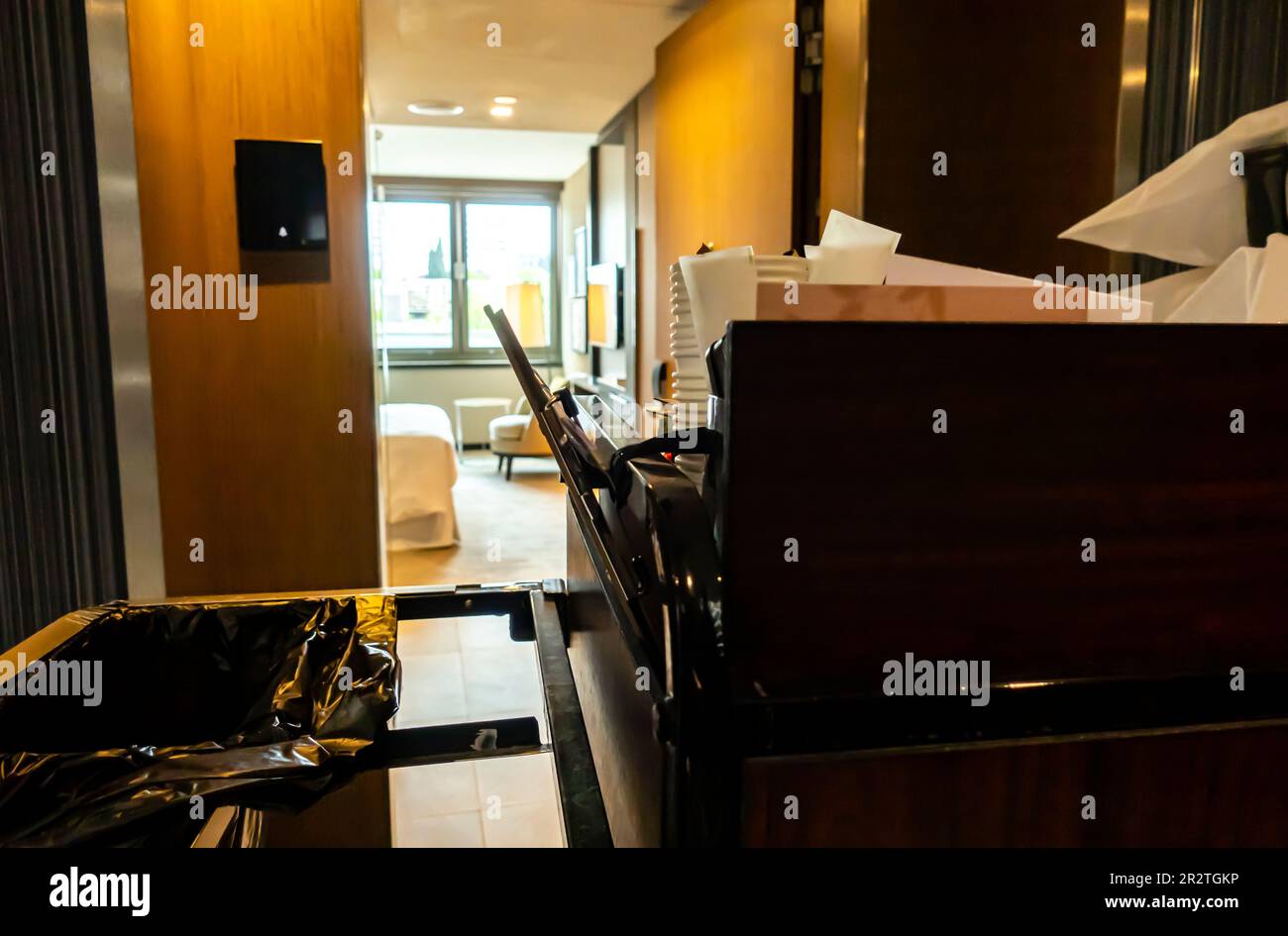 Housekeeping cart in a hotel corridor. Cleaning hospitality housekeeper's trolley beside a room entrance Stock Photo