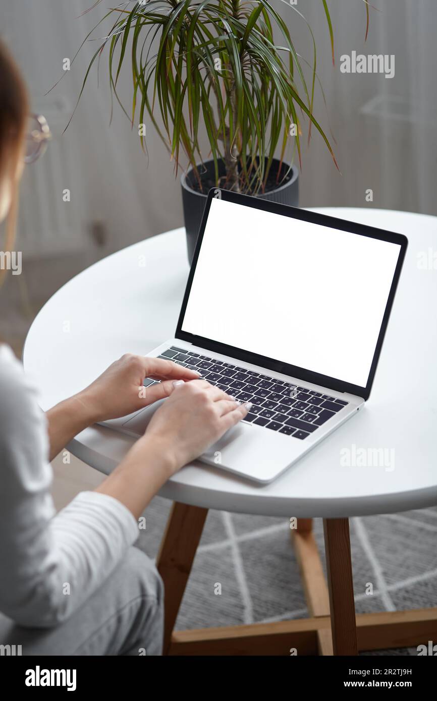 Mockup white screen laptop woman using computer while sitting at table ...