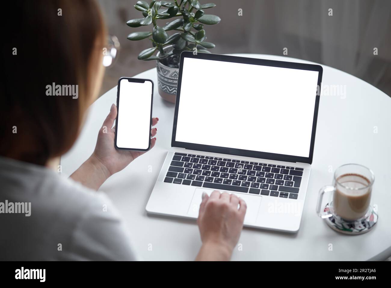 Mockup white screen laptop and mobile phone woman using computer while ...