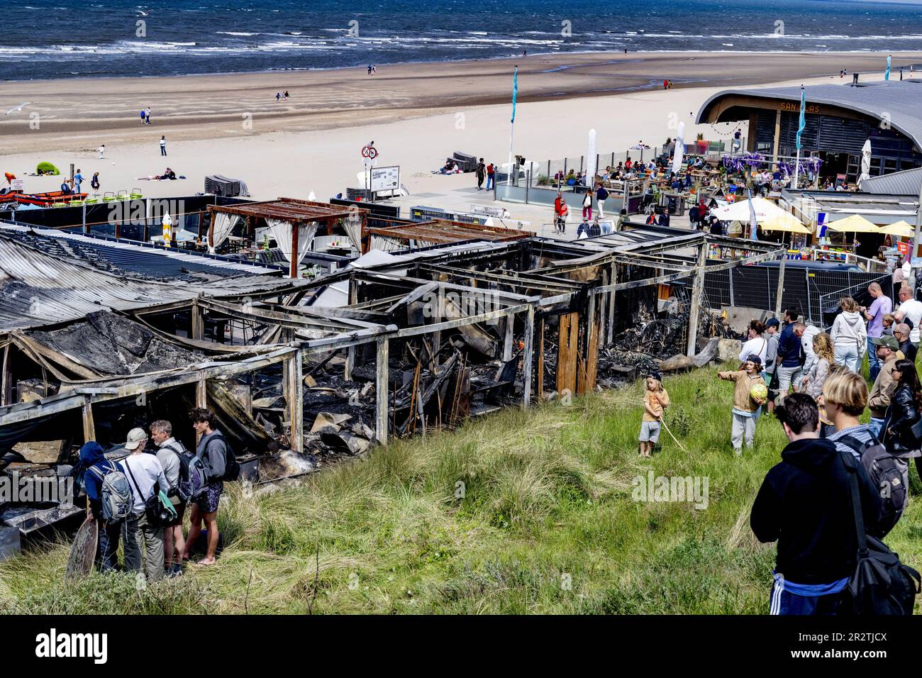 BLOEMENDAAL - Beachgoers at the burnt-down beach bar Bloomingdale. The owners of the famous beach club in Bloemendaal aan Zee feel great bewilderment and a lot of sadness about the burning down of their famous beach pavilion. ANP ROBIN UTRECHT netherlands out - belgium out Credit: ANP/Alamy Live News Stock Photo