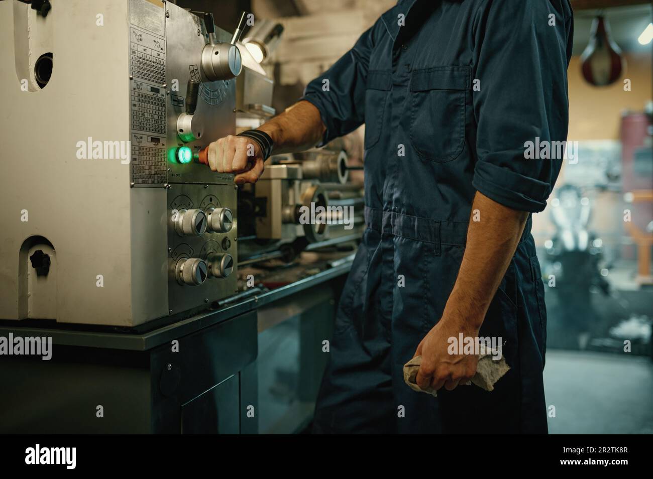 Closeup repairman hand turning off lathe machine with toggle switch ...