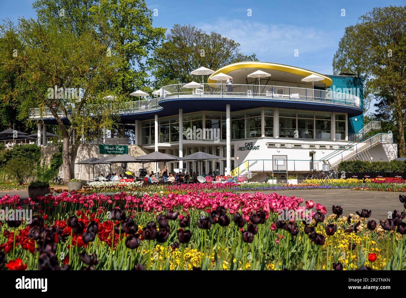 the historic Park Café  in the Rhine Park in the district Deutz, local recreation area, beds with tulips, Cologne, Germany. das historische Park-Café Stock Photo