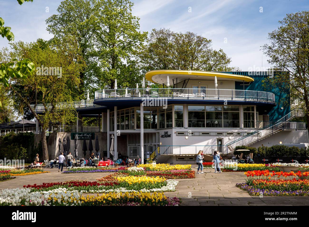 the historic Park Café  in the Rhine Park in the district Deutz, local recreation area, beds with tulips, Cologne, Germany. das historische Park-Café Stock Photo