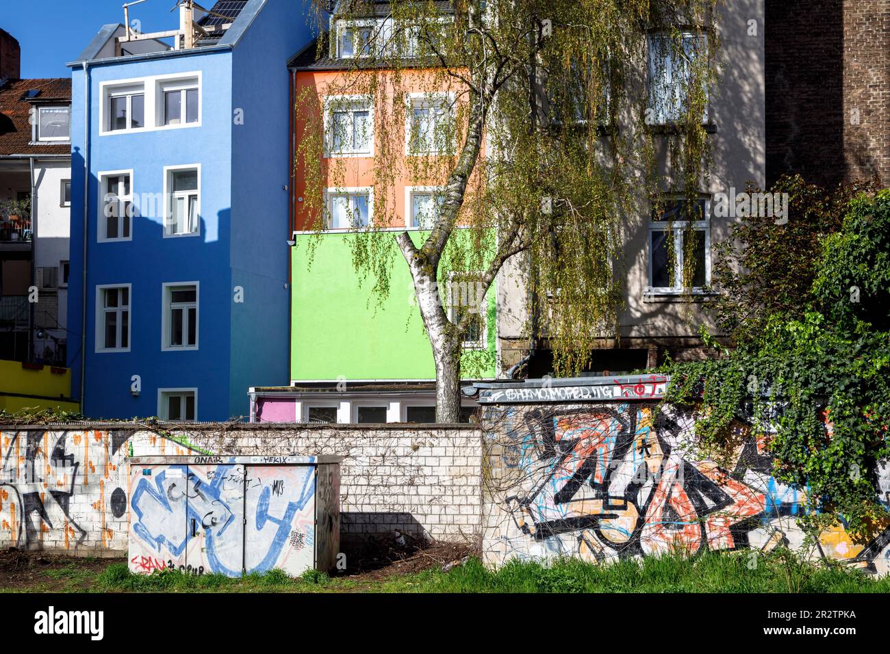 wall with graffiti and colorful house facades in Eigelstein quarter ...