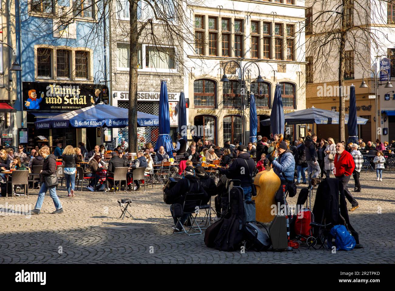 people sitting in front of pubs at the Old Market in the old part of the town, at right the pub Gaffel, buskers, Cologne, Germany. Menschen sitzen vor Stock Photo