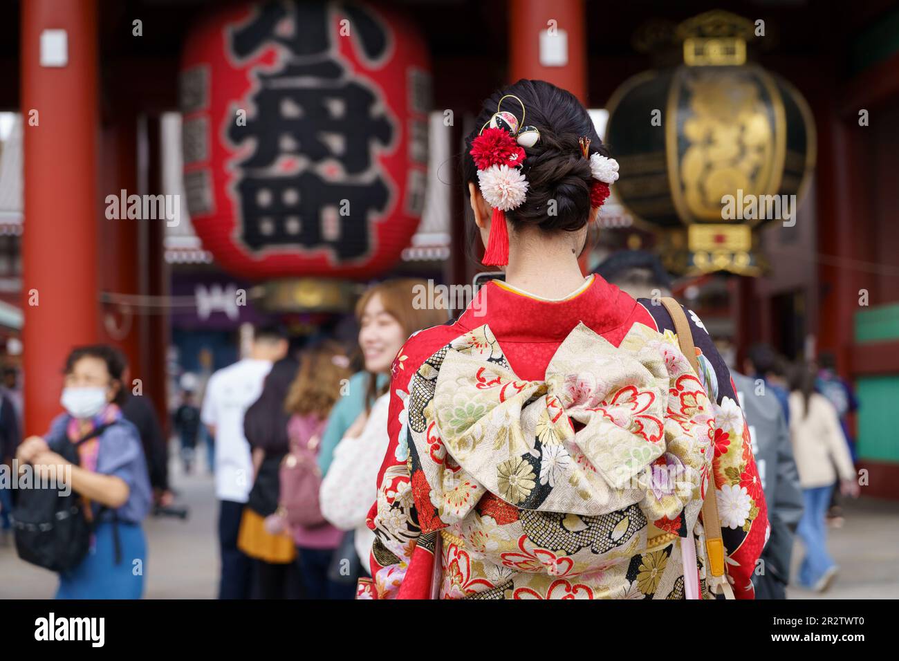 Young girl wearing Japanese kimono standing in front of Sensoji Temple