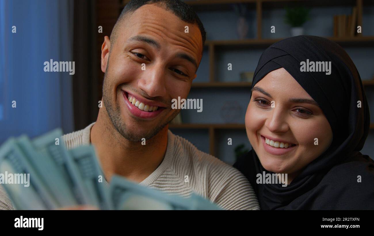 Rich multiracial couple spouses African American man counting money