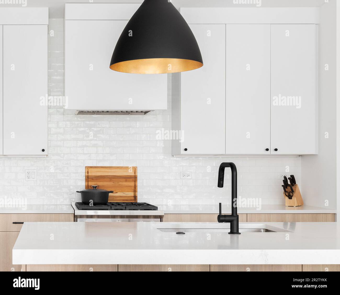 A beautiful kitchen with dark wood cabinets, marble countertops, chairs  sitting at the island, and stainless steel appliances. No brands or names  Stock Photo - Alamy