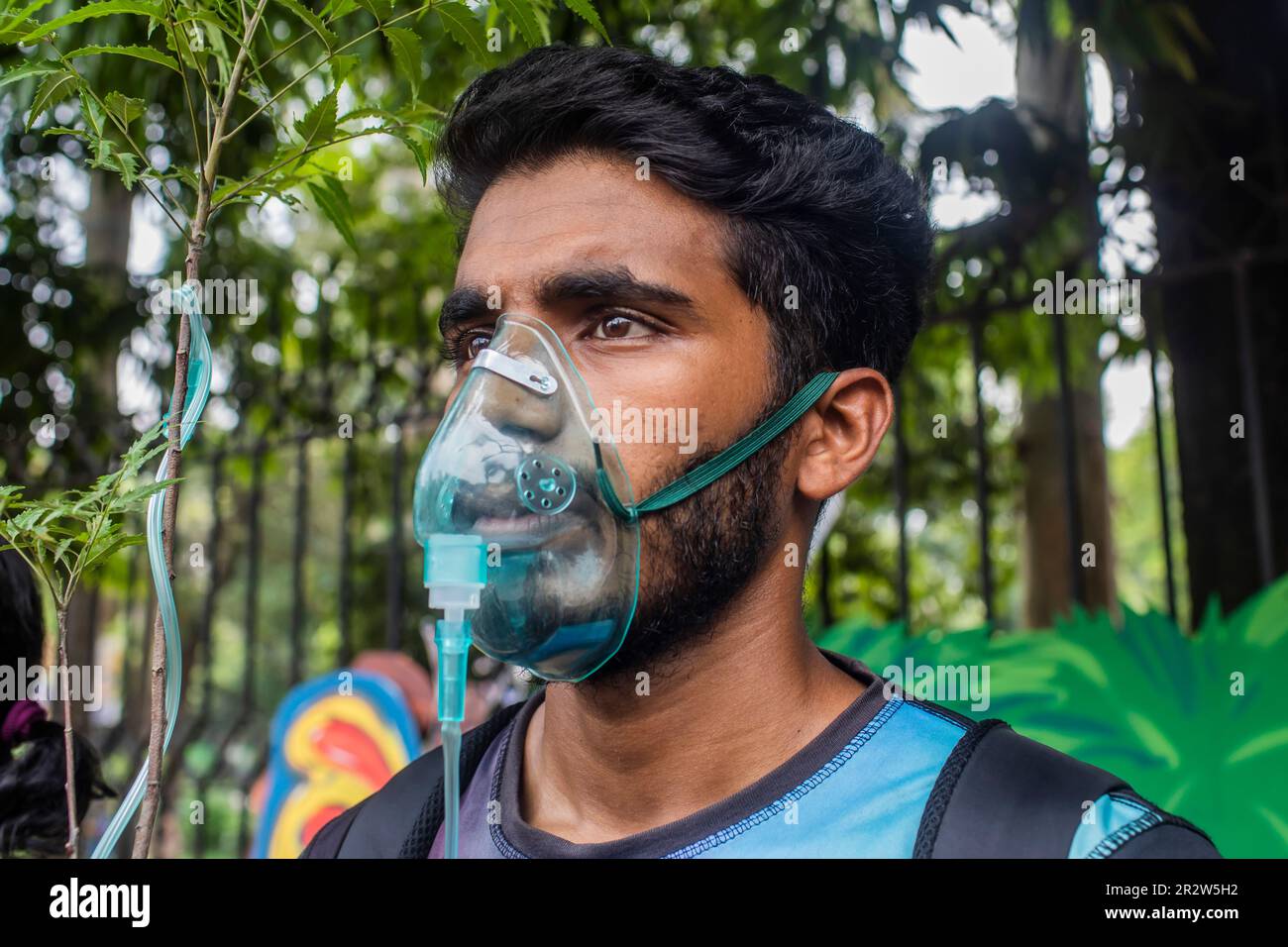 Dhaka, Bangladesh. 21st May, 2023. A protester with an oxygen mask takes part during the demonstration. Dhaka Metropolitan Police (DMP) has blocked environmental activists - under the banner of 'Saat Masjid Sarak Gach Rakkha Andalan' - from laying siege on Dhaka South City Corporation (DSCC) protesting against the felling of trees in the name of beautification of Dhanmondi's Saat Masjid Road. Credit: SOPA Images Limited/Alamy Live News Stock Photo