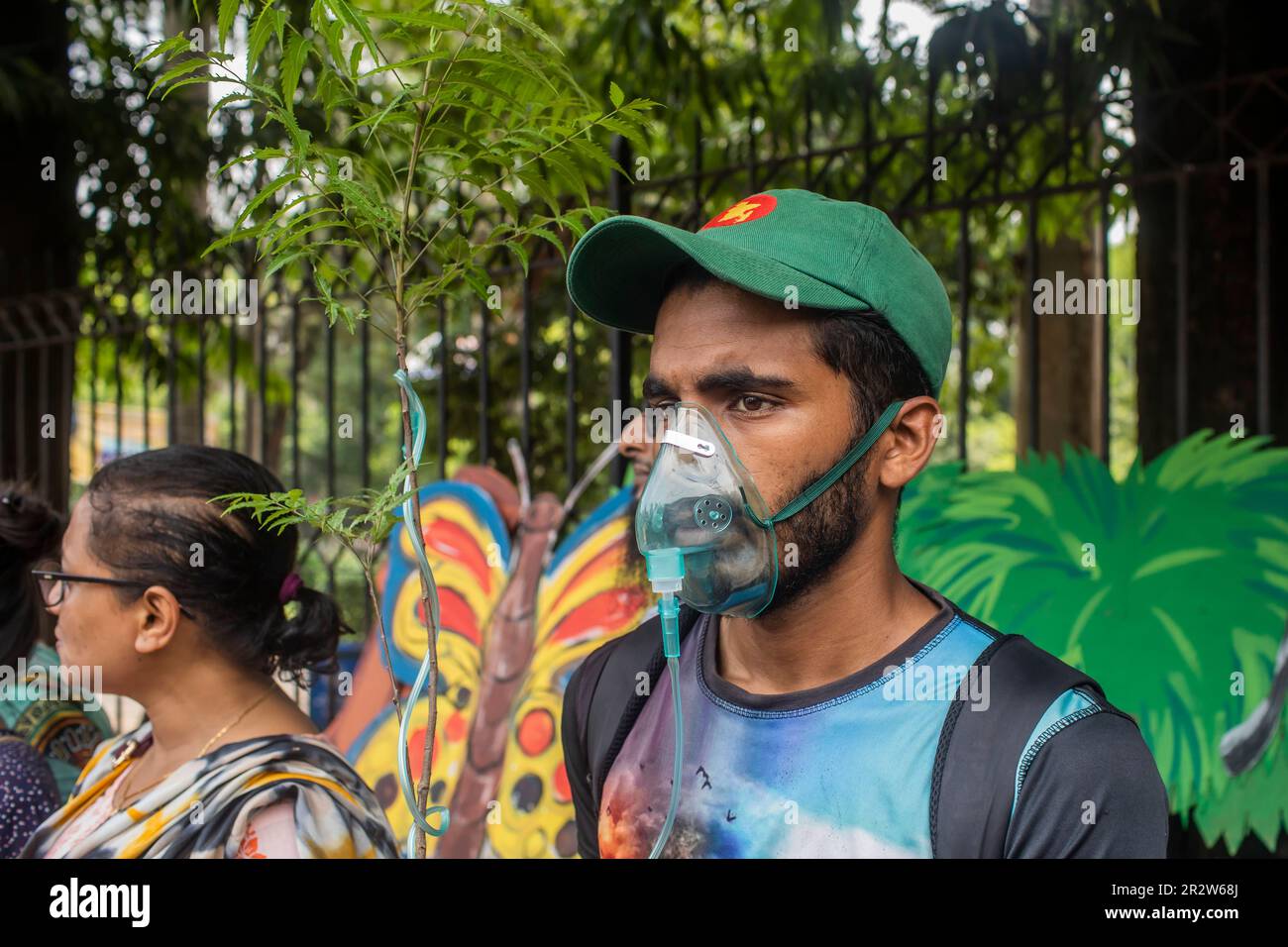 Dhaka, Bangladesh. 21st May, 2023. A protester with an oxygen mask takes part during the demonstration. Dhaka Metropolitan Police (DMP) has blocked environmental activists - under the banner of 'Saat Masjid Sarak Gach Rakkha Andalan' - from laying siege on Dhaka South City Corporation (DSCC) protesting against the felling of trees in the name of beautification of Dhanmondi's Saat Masjid Road. (Photo by Sazzad Hossain/SOPA Images/Sipa USA) Credit: Sipa USA/Alamy Live News Stock Photo