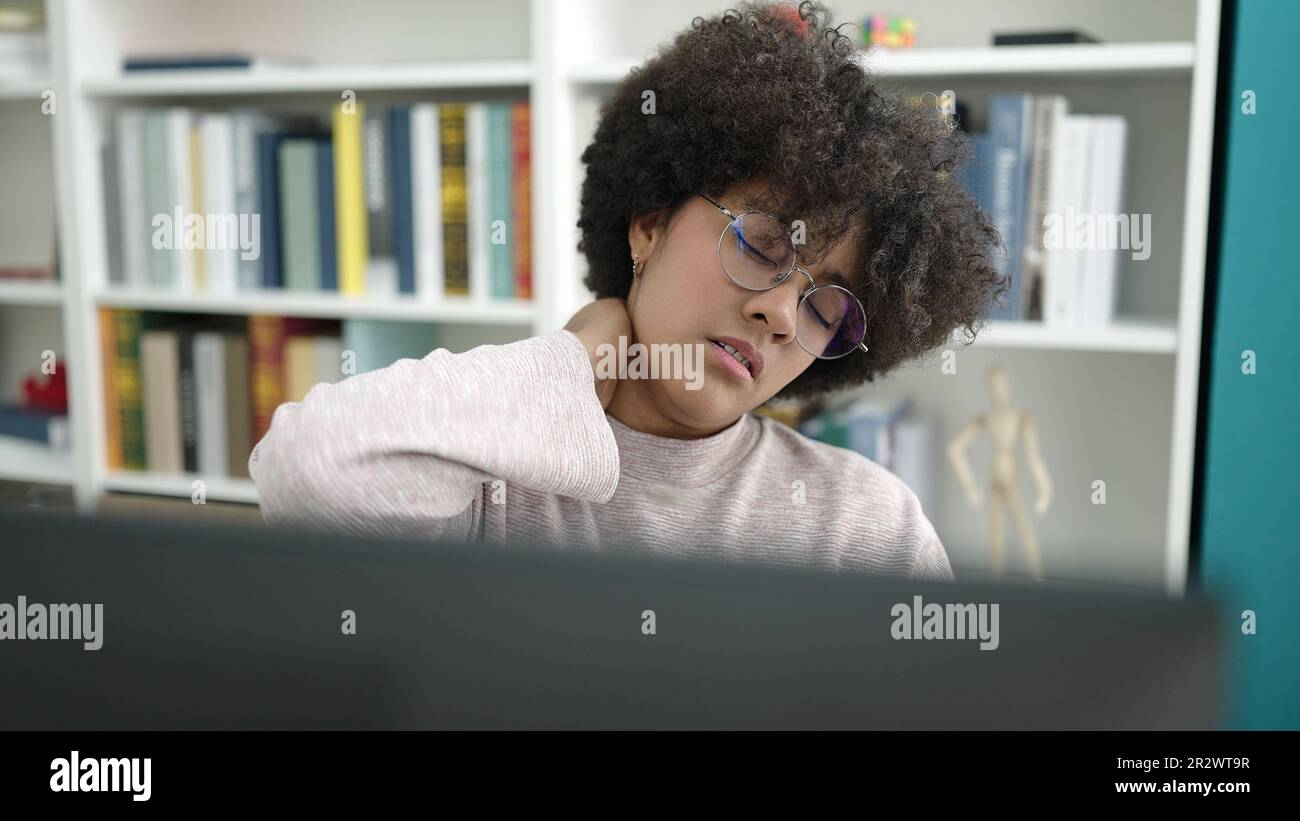 Young african american woman student using computer stressed at ...