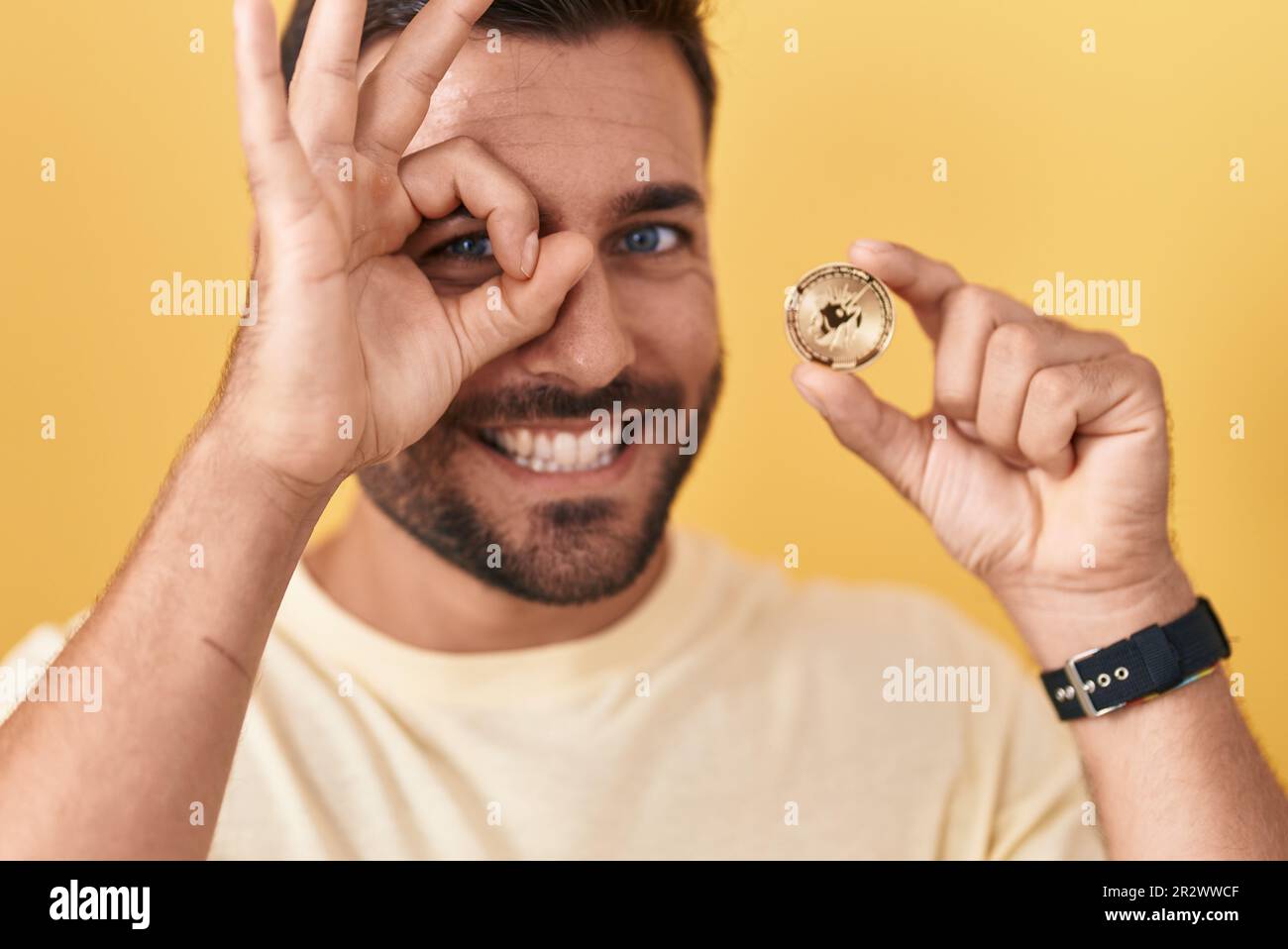 Handsome hispanic man holding uniswap cryptocurrency coin smiling happy  doing ok sign with hand on eye looking through fingers Stock Photo - Alamy