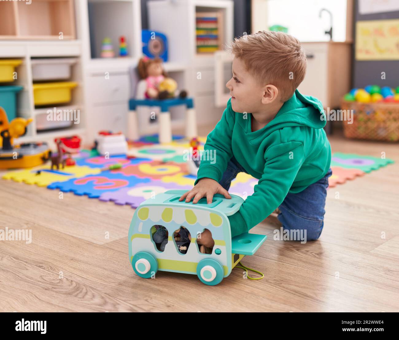 Adorable caucasian boy playing with car toy sitting on floor at ...