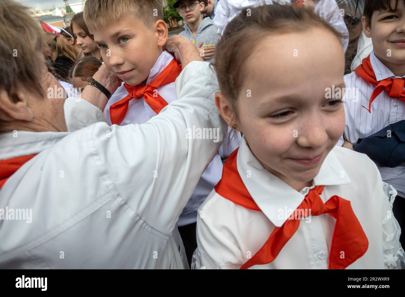 Moscow, Russia. 21st of May, 2023. Old woman ties a red neckerchief for