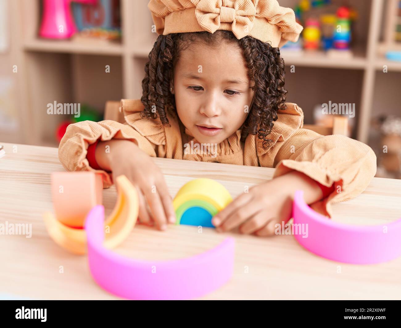 African american girl playing with wooden construction blocks sitting