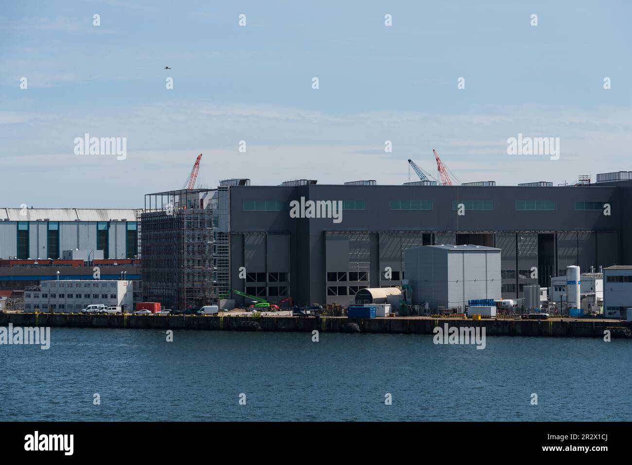 Blick über die Kieler Innenförde auf die Marineschiffswerft von ThyssenKrupp mit den Neubauten der Produktionshallen für Uboote der neuesten Generatio Stock Photo