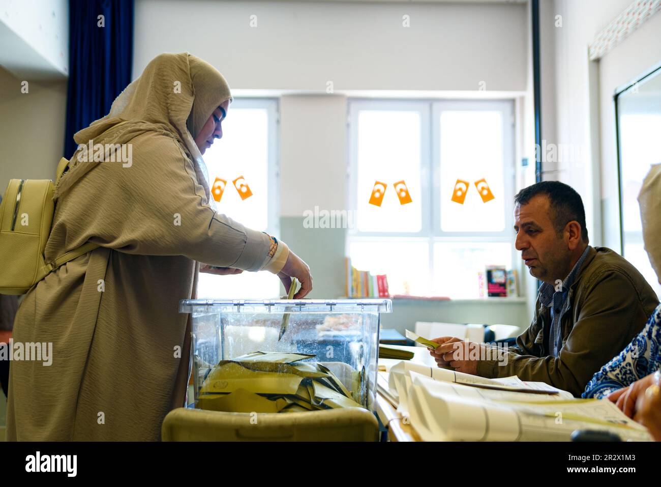 A young woman in traditional muslim clothes is seen close up voting at Saffet Çebi school. 64 millions turkish citizens are called to head to the poll Stock Photo