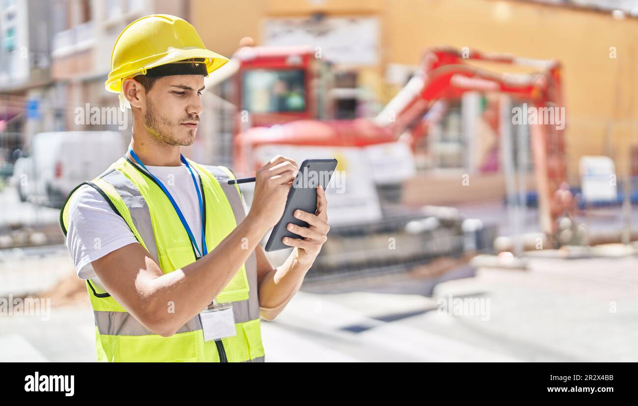 Young hispanic man architect drawing on touchpad at park Stock Photo