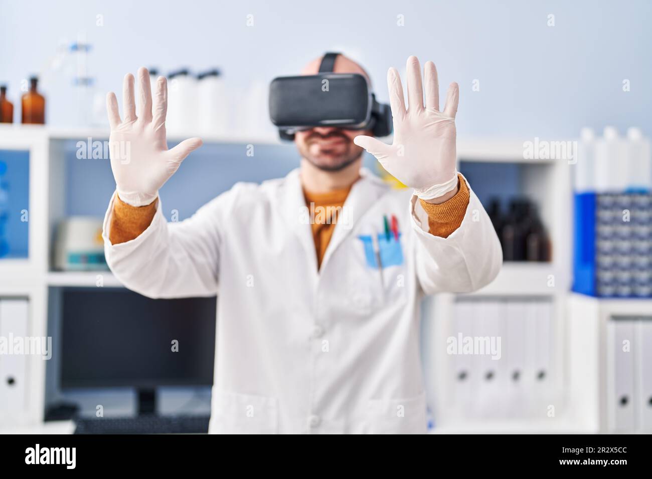 Young man scientist using virtual reality goggles at laboratory Stock Photo
